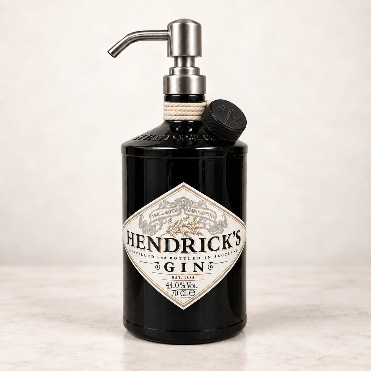 Dispenser Hendrick’s nero con dosatore argento, tappo nero e corda avvolta al collo — immagine illustrativa